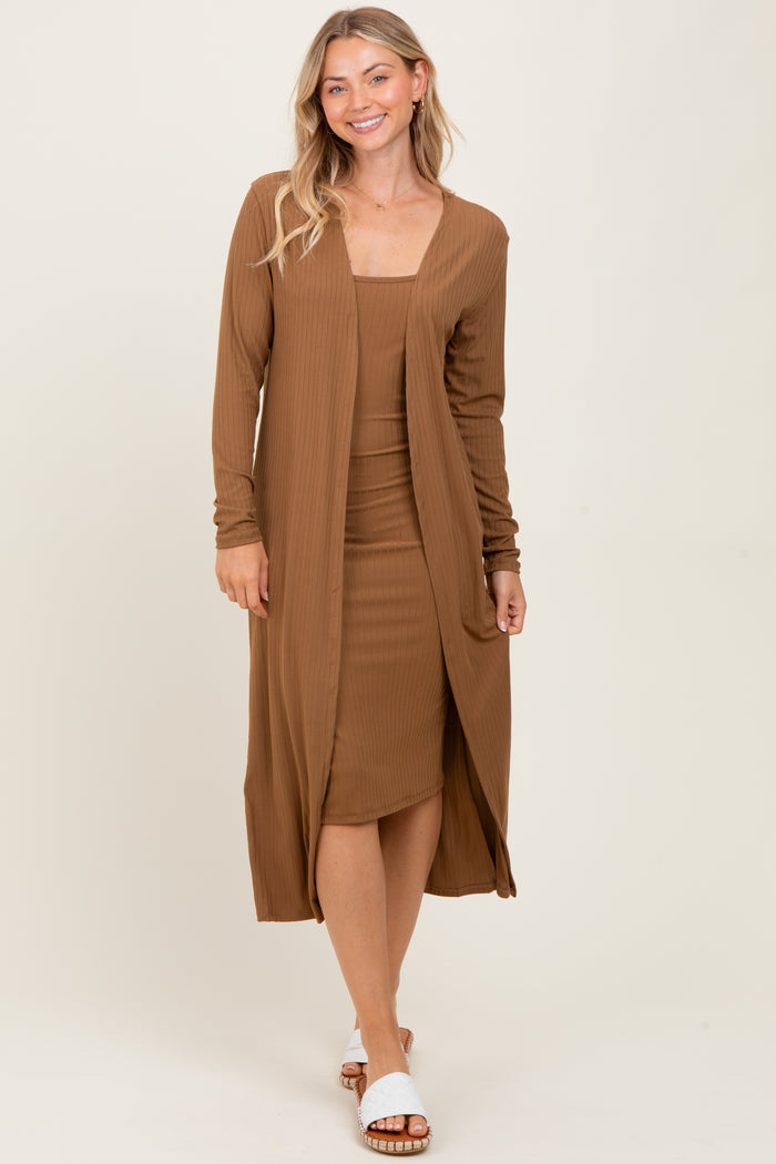 woman wearing a brown ribbed midi dress with a matching long cardigan and white slide sandals