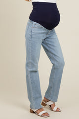 woman wearing light wash maternity jeans with a navy blue over-the-bump panel and a visible baby bump