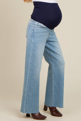 woman wearing light blue wide-leg maternity jeans with a dark blue over-the-bump waistband and a visible baby bump