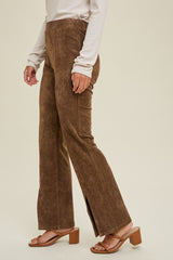woman wearing brown suede flared pants with side slits and a cream long sleeve top, standing sideways