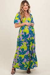 woman wearing a colorful floral print maternity maxi dress with puff sleeves and a relaxed fit, showing baby bump