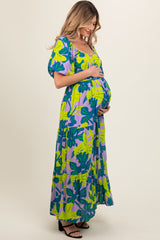 woman wearing a colorful floral maternity maxi dress and showcasing her baby bump