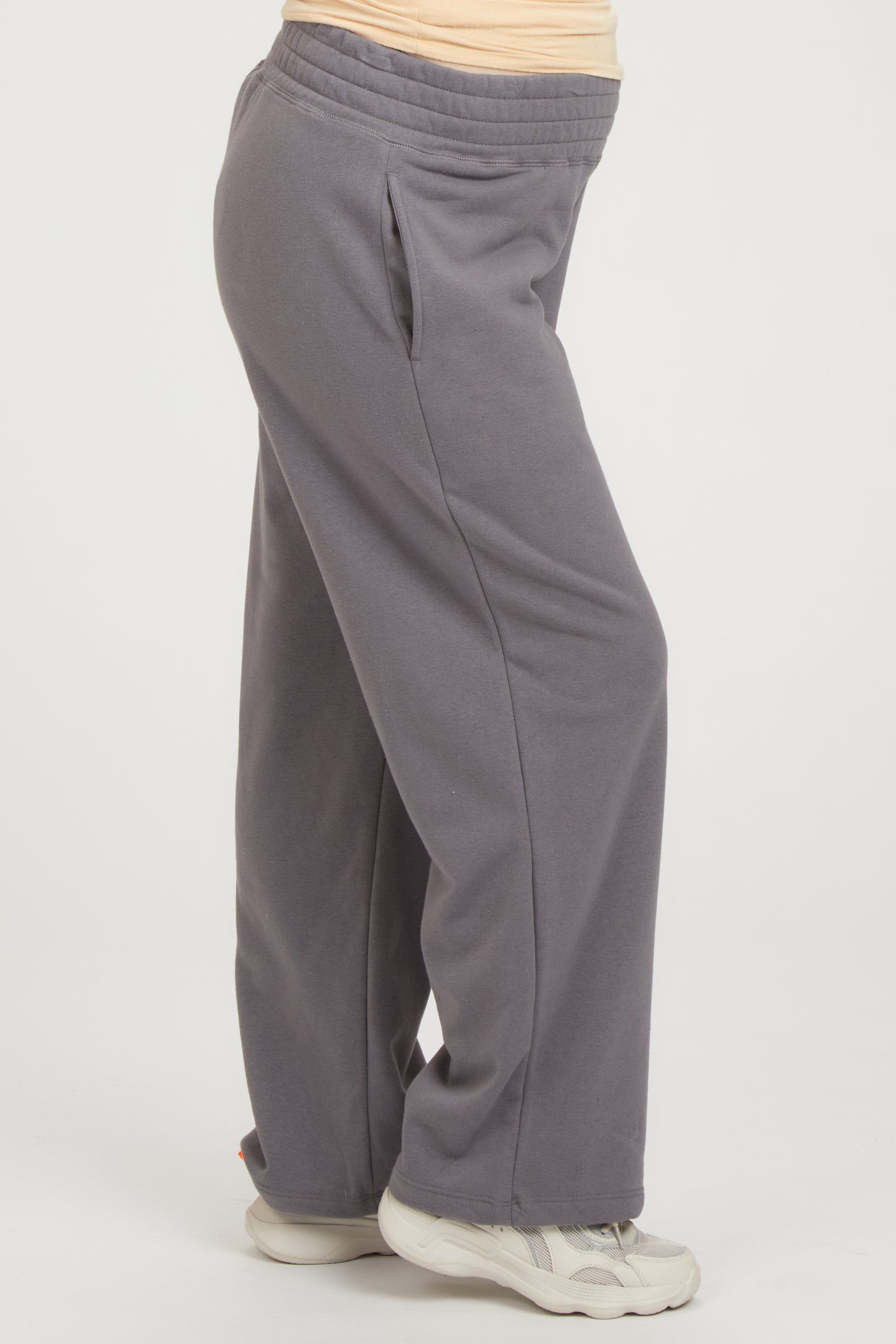 woman wearing grey maternity sweatpants with side pockets and an elastic waistband, highlighting her baby bump