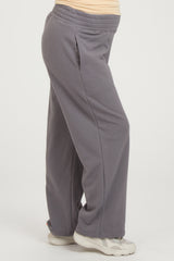 woman wearing grey maternity sweatpants with side pockets and an elastic waistband, highlighting her baby bump