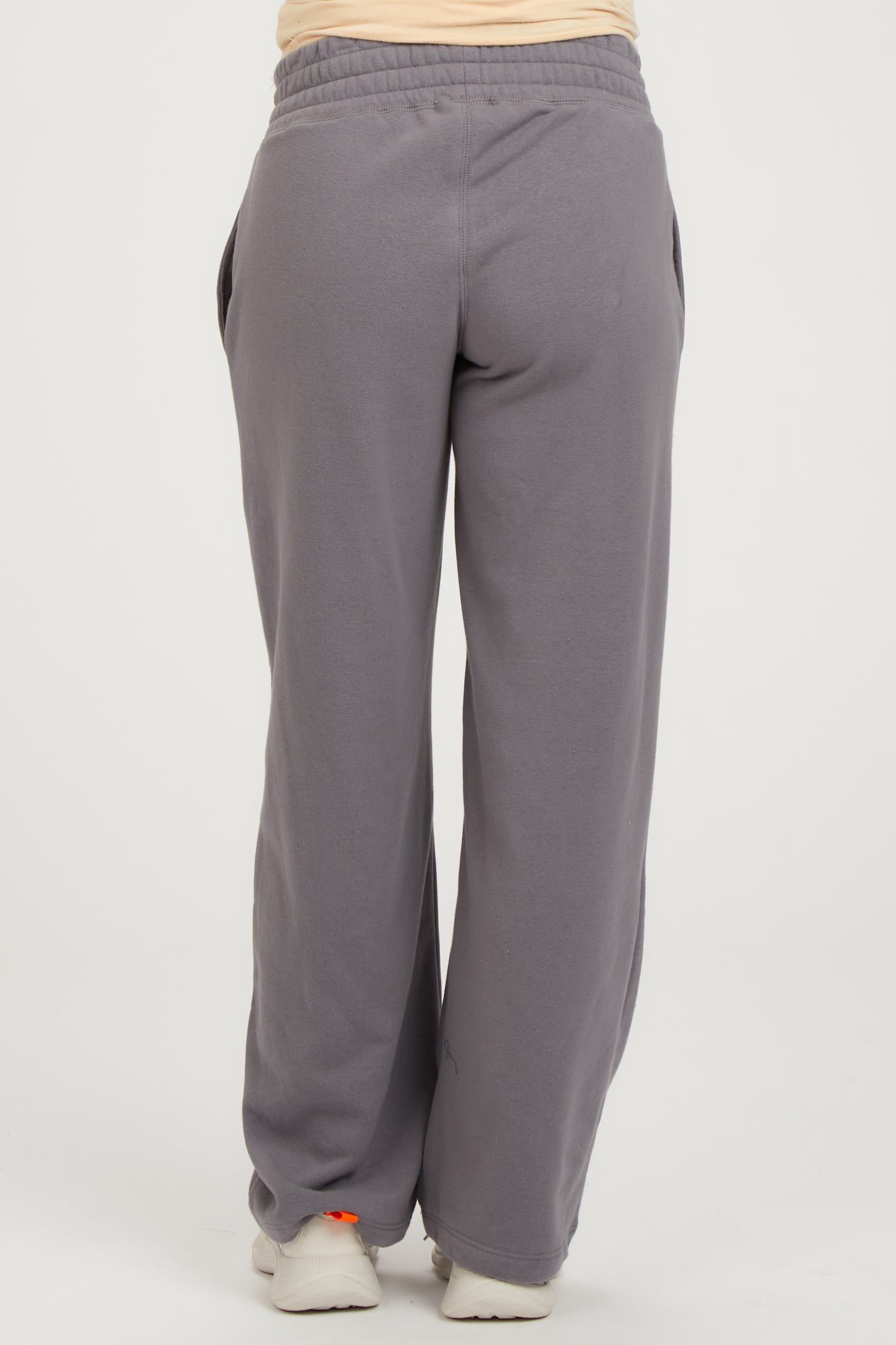 woman wearing gray maternity sweatpants with a relaxed fit and side pockets, showing the back view