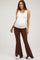 woman wearing a white maternity tank top and brown flared maternity pants, showcasing her baby bump