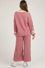 woman wearing a pink maternity lounge set with wide-leg pants and long sleeve top, casual style from the back