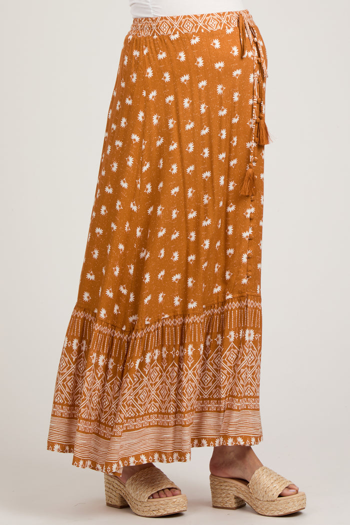 maternity wear long brown printed maxi skirt with tassel detail and tiered hem, model wearing it with casual sandals