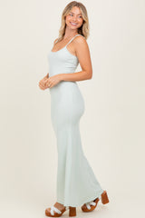woman wearing a light green ribbed maxi dress with spaghetti straps and platform sandals