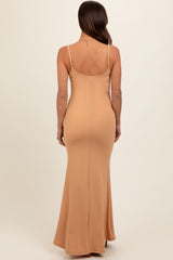 woman wearing a nude fitted maternity maxi dress with a long skirt and spaghetti straps