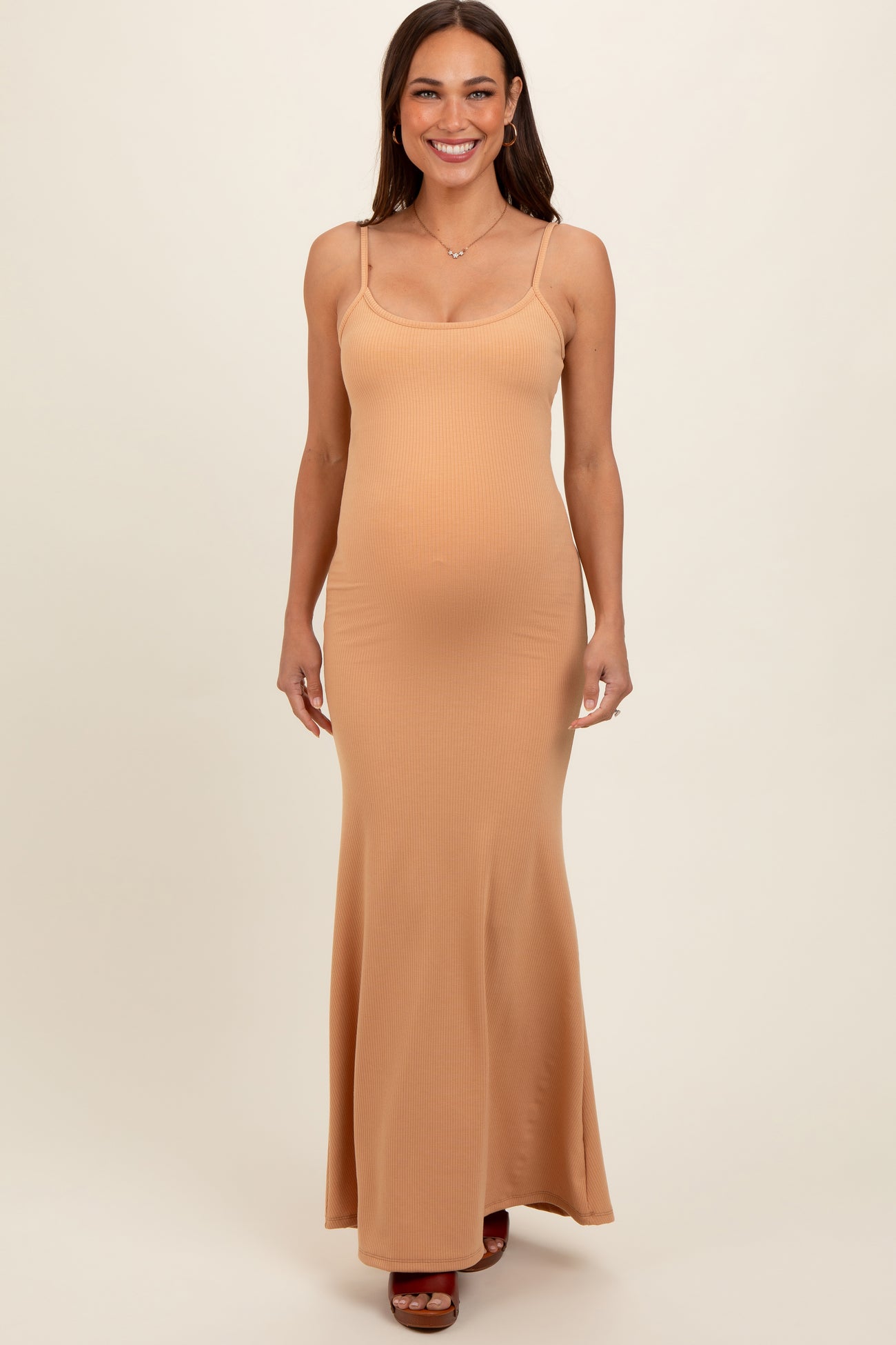 woman wearing a light brown ribbed maternity maxi dress with thin straps and showing her baby bump