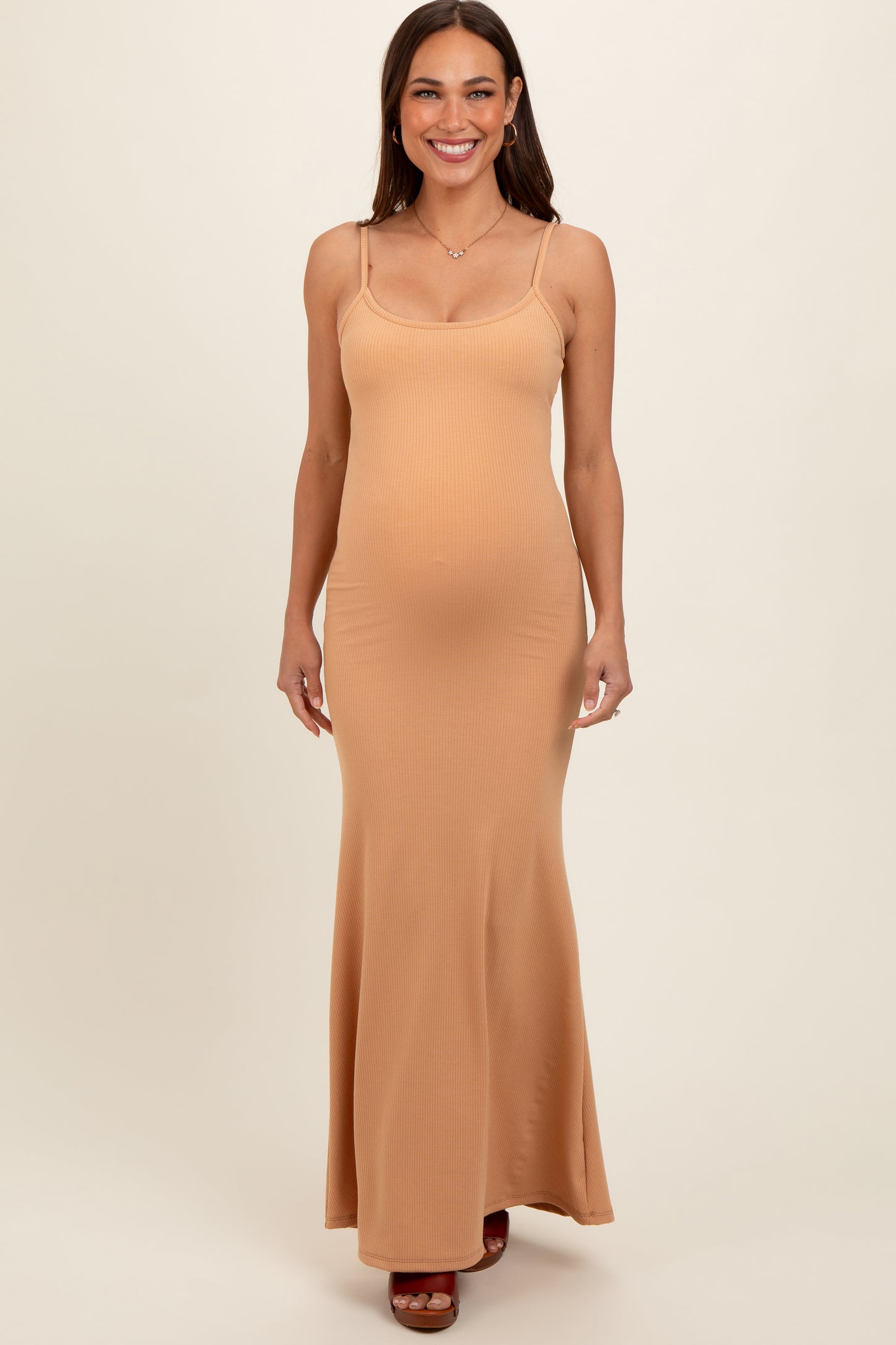 woman wearing a light brown ribbed maternity maxi dress with thin straps and showing her baby bump