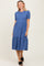 woman wearing a short sleeve blue tiered midi dress and black slide sandals