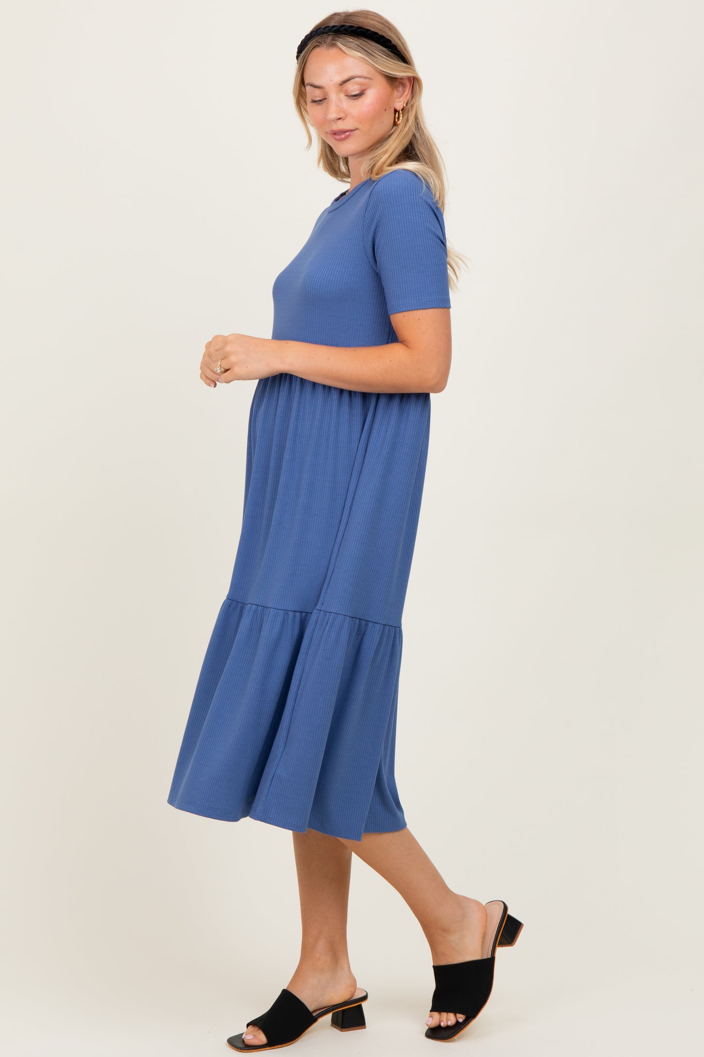 woman wearing a blue short sleeve tiered midi dress and black slide sandals