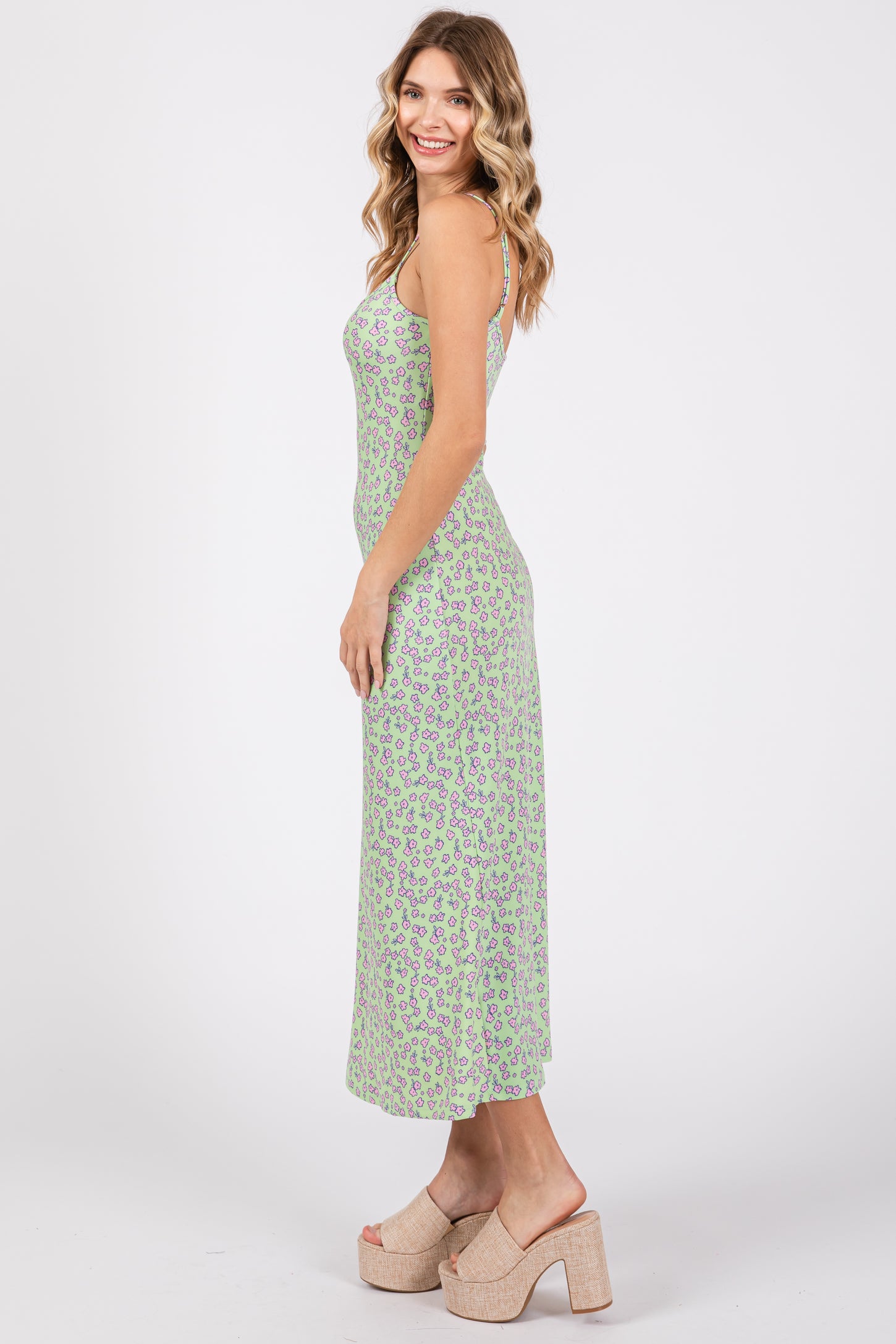 woman wearing a green floral print maxi dress with spaghetti straps and cork wedge sandals
