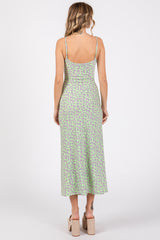 woman wearing a light green floral midi dress with adjustable straps and a fitted silhouette, showing the back view