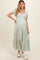 woman wearing a floral print maternity maxi dress with puff sleeves and a tiered hem, showcasing her baby bump