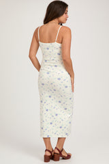 woman wearing a floral print maternity midi dress with spaghetti straps and a fitted silhouette