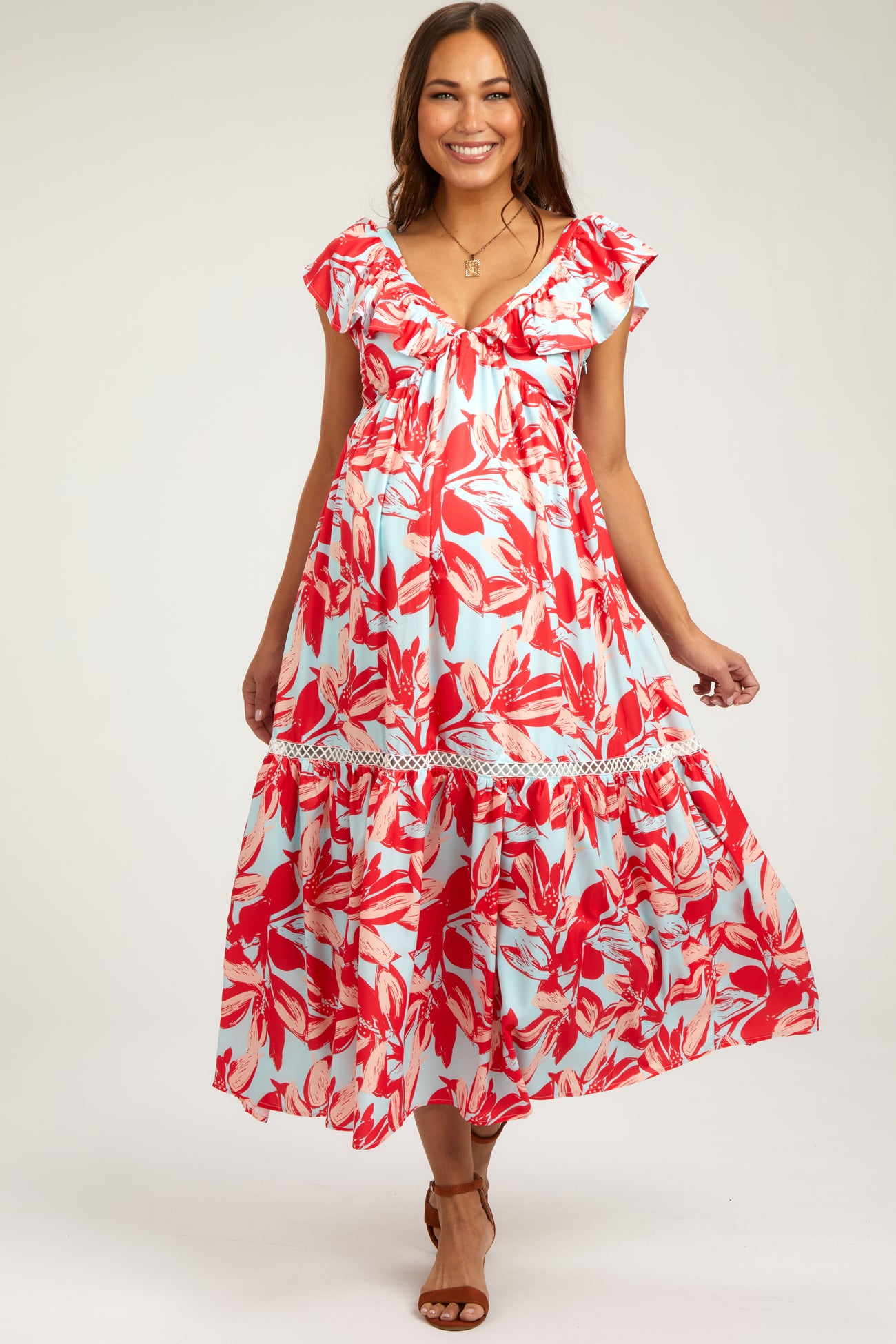 woman wearing a red and light blue floral maternity dress with ruffled sleeves and a tiered skirt