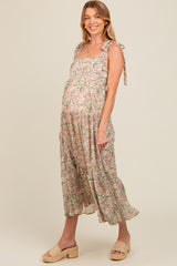 woman wearing a floral maternity maxi dress with tie straps and a visible baby bump