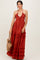 woman wearing a rust red halter maxi dress with ruffle details, holding a woven bag
