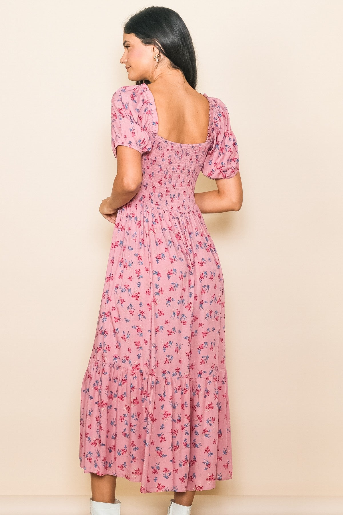 woman wearing a pink floral midi dress with short puff sleeves and a square back, shown from the back