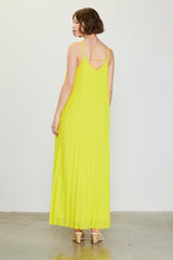 woman wearing a bright yellow pleated maxi dress with spaghetti straps and a V-back design
