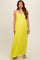 woman wearing a bright yellow pleated maternity maxi dress with spaghetti straps and a flowing silhouette