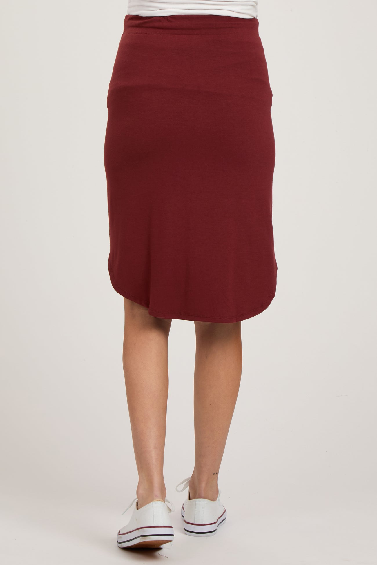 woman wearing a burgundy maternity pencil skirt, view from the back, with a comfortable waistband and knee-length cut