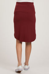 woman wearing a burgundy maternity pencil skirt, view from the back, with a comfortable waistband and knee-length cut