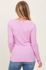 woman wearing a light pink ribbed long sleeve top, shown from the back with casual jeans