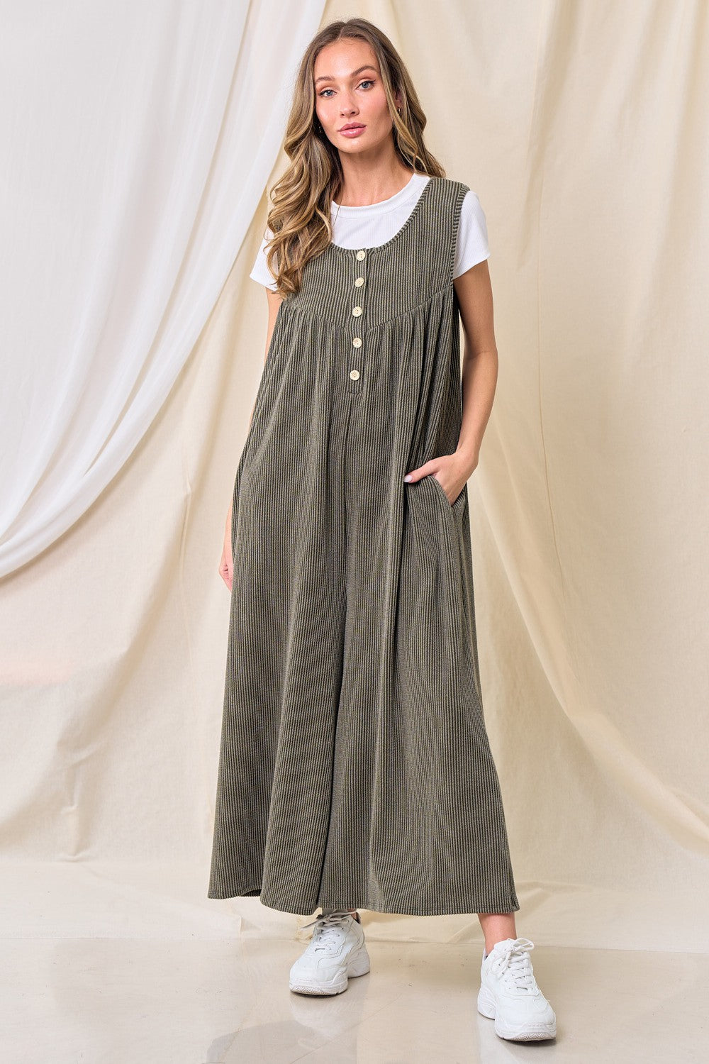 woman wearing an olive green striped maxi dress with buttons and pockets over a white t-shirt