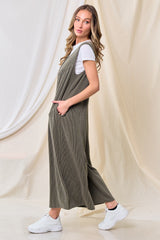 woman wearing a long olive green ribbed jumper dress over a white t-shirt, styled with white sneakers