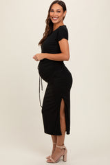 woman wearing a black short sleeve maternity dress with side ruching and a visible baby bump