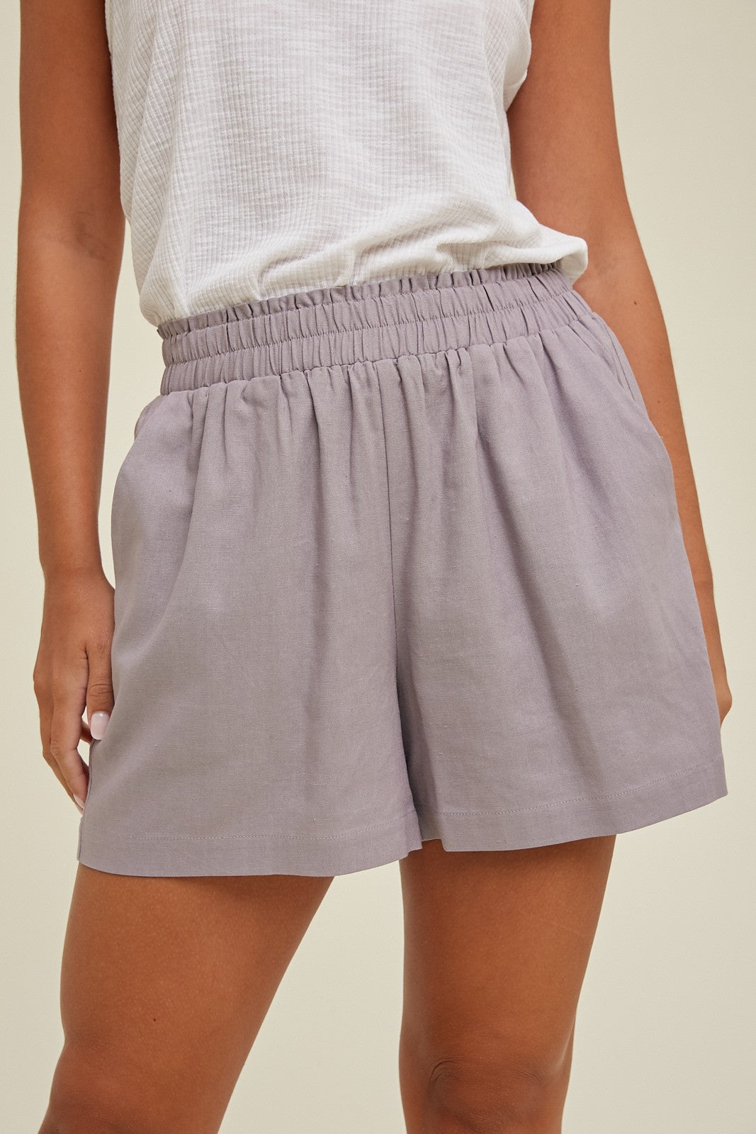 woman wearing light purple elastic waist shorts with a relaxed fit and side pockets