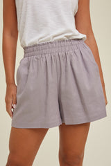 woman wearing light purple elastic waist shorts with a relaxed fit and side pockets