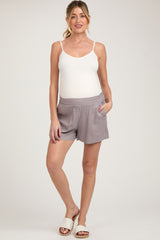 woman wearing gray maternity shorts and a white tank top with a relaxed fit and pockets