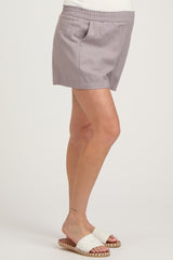 woman wearing light gray maternity shorts with an elastic waistband and a relaxed fit, showing a baby bump