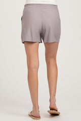woman wearing light gray maternity shorts, seen from the back