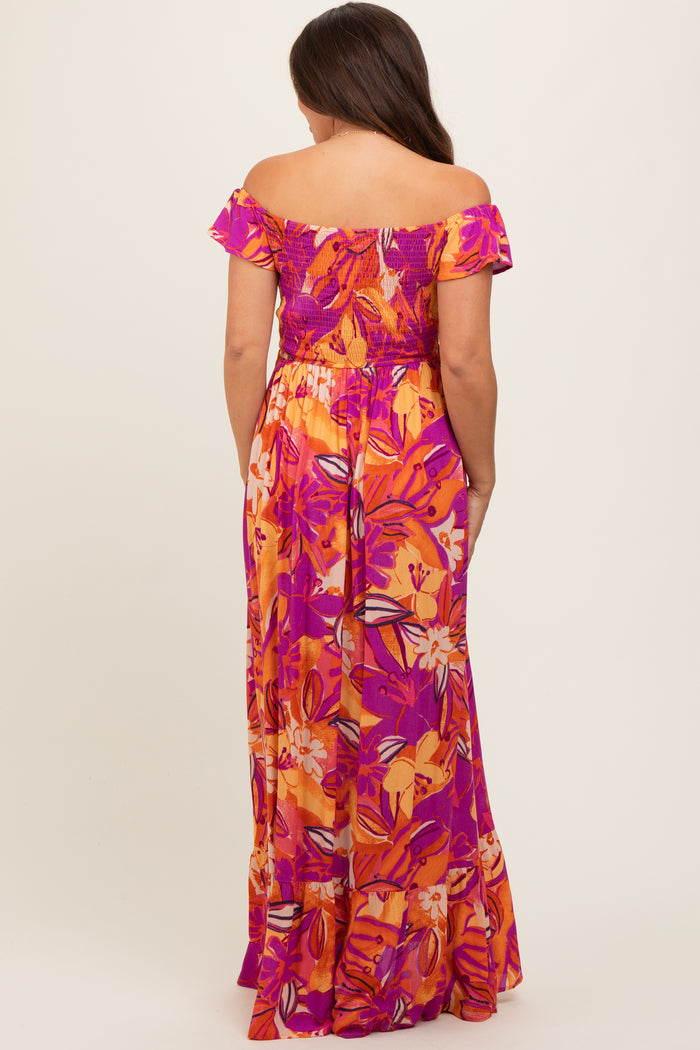 woman wearing a colorful off-the-shoulder floral maxi dress, showcasing a smocked bodice and tiered skirt, maternity wear
