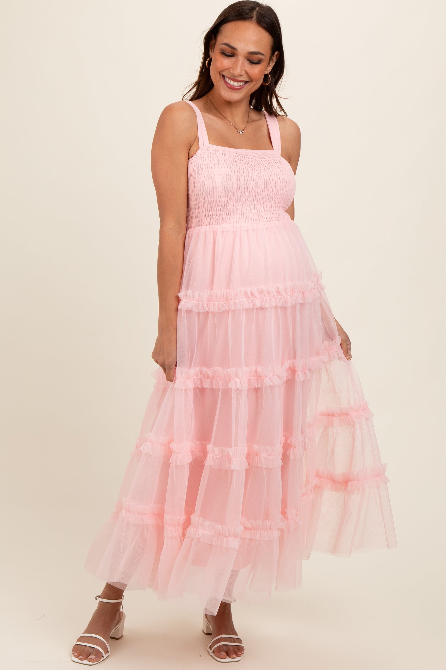 woman wearing a pink tiered tulle maternity dress with smocked bodice and baby bump visible