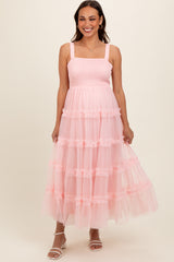 woman wearing a pink maternity maxi dress with smocked bodice and ruffled tiers