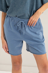 woman wearing light blue casual shorts with an elastic waistband and drawstring detail