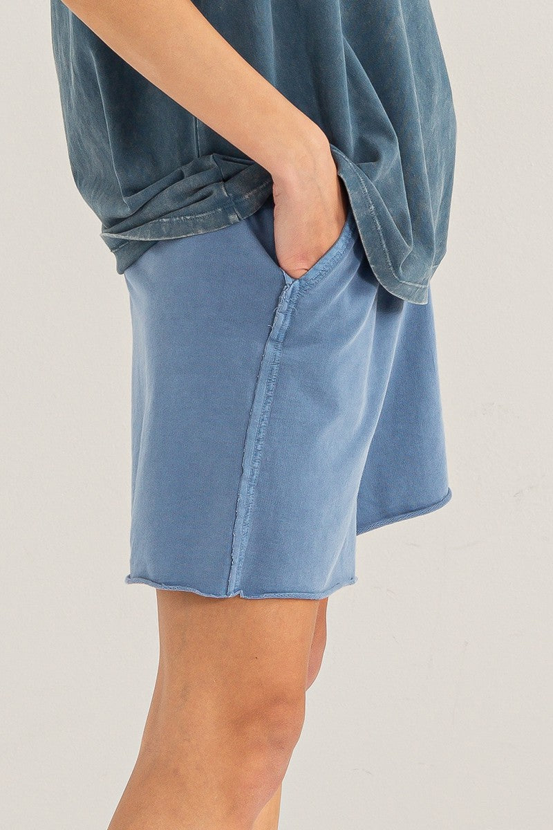 woman wearing blue relaxed fit shorts with an elastic waistband and side pockets