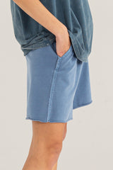 woman wearing blue relaxed fit shorts with an elastic waistband and side pockets