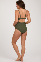 woman wearing a dark green maternity swimsuit with adjustable straps and a scoop back