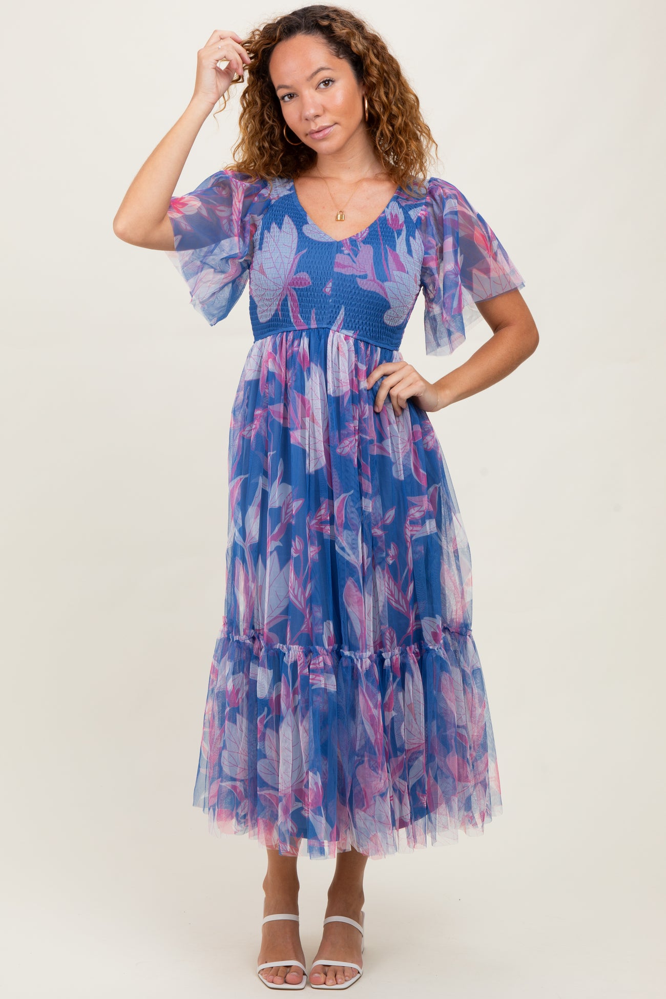woman wearing a blue floral tulle maxi dress with puff sleeves and a tiered hem