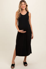 woman wearing a black sleeveless maternity dress with a side slit and holding her baby bump