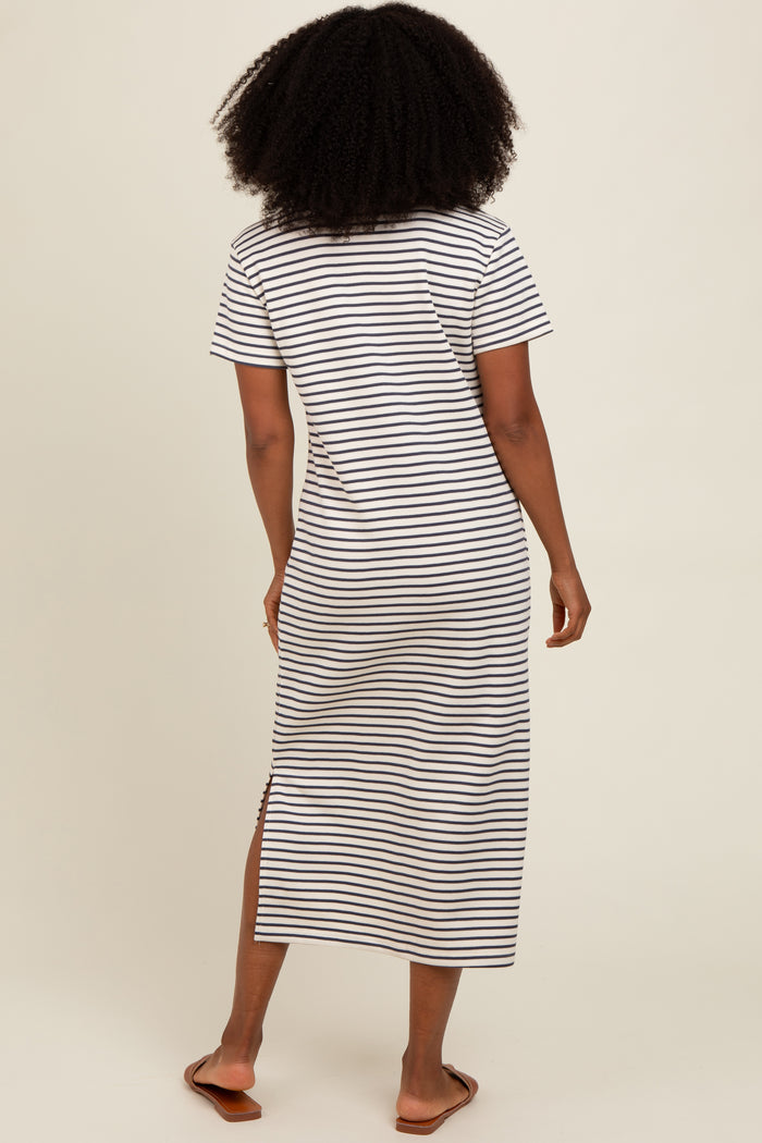 woman wearing a black and white striped maxi dress with short sleeves and side slits, viewed from the back