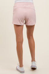 woman wearing light pink maternity shorts, seen from the back, casual style with a relaxed fit